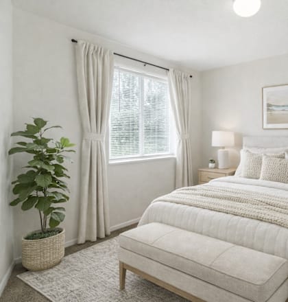 A bedroom with a large bed, a potted plant, and a framed picture on the wall. at Diamond Fork Apartments, Utah, 84660