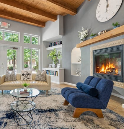 A living room with a fireplace and blue chairs.