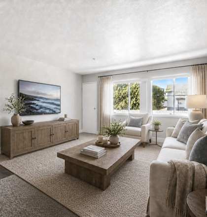 A living room with a large flat screen TV mounted on the wall.