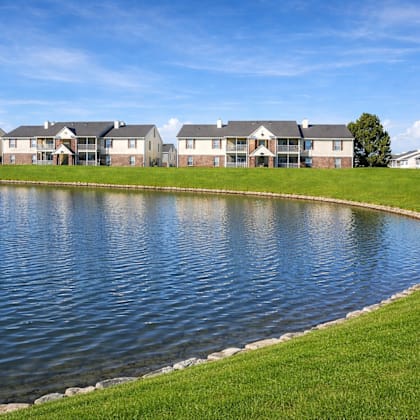 A row of houses with a pond in front.