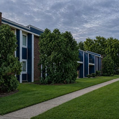 A long grassy pathway leads to a building.
