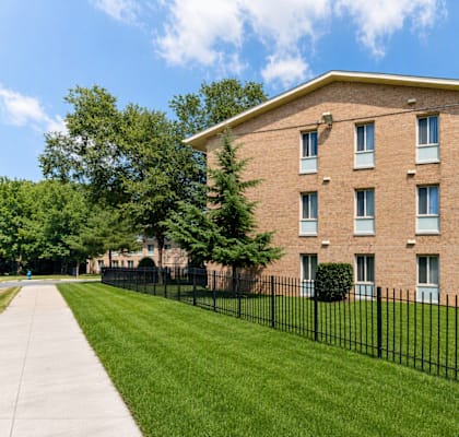 A brick building with a black fence in front.