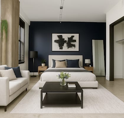 A modern living room with a white sofa, a black coffee table, and a large abstract painting on the wall.