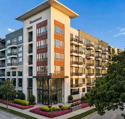 A modern apartment building with a variety of balconies and windows.