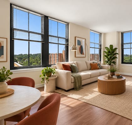 A living room with a white couch and a large window.