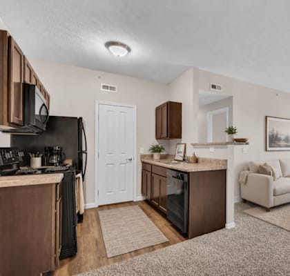 A well-lit, modern kitchen with a dining area and a living room.
