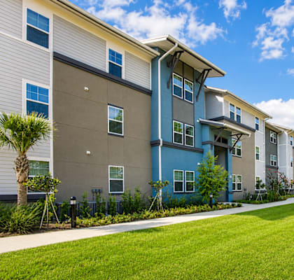 A row of modern apartment buildings with green lawns in front.