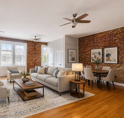 A living room with a brick wall and a fireplace.