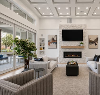 A living room with a fireplace and grey couches.