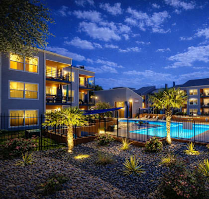 A modern building with a pool in the courtyard at dusk. at Infinity on the Landing Apartments , Apartments, Euless, TX