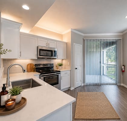 A kitchen with white cabinets and a stainless steel oven.