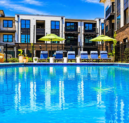 A swimming pool with a reflection of the surrounding buildings.
