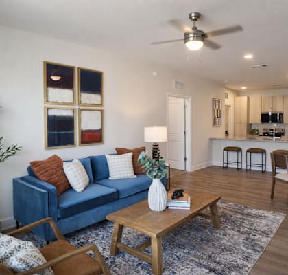A living room with a blue couch and a wooden coffee table.