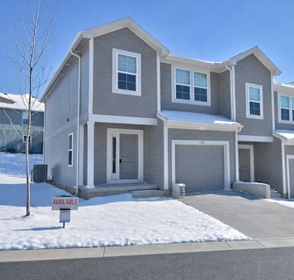 A row of houses with a sign that says "available" in front of the first one.