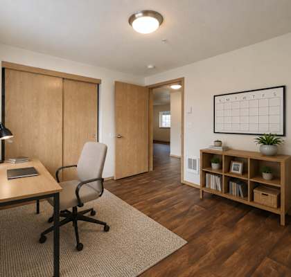 A modern office with a desk, chair, and a plant.