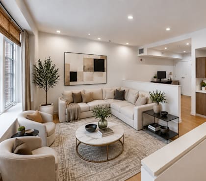 A living room with a white couch, a coffee table, and a painting on the wall.