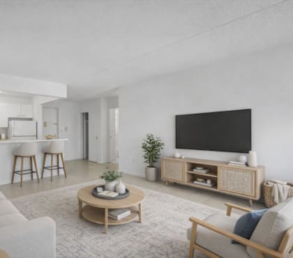 A modern living room with a grey sofa, a wooden coffee table, and a black television.