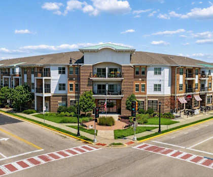 A street view of a residential area with apartment buildings and a pedestrian crossing.