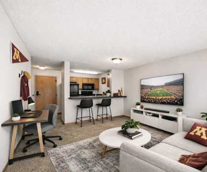 A living room with a grey couch, a wooden desk, and a television.