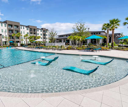 A swimming pool with a blue tiled edge and a metal railing. at AVLI AT CROSSTOWN CENTER Apartments , TAMPA, FL, 33619