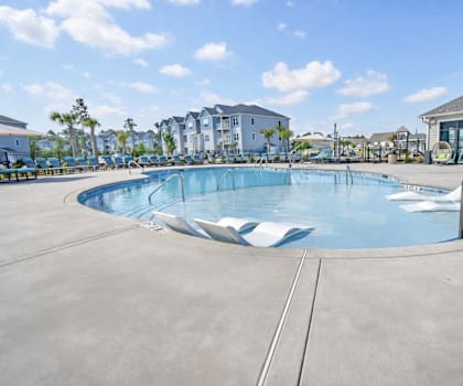A large outdoor swimming pool with a metal ladder. at GRANDVIEW AT CLEAR POND Apartments , MYRTLE BEACH, SC, 29579