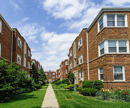 A long brick building with a walkway in between.
