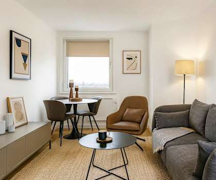 A living room with a grey couch, a brown chair, and a black table.