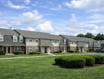 A row of houses with green lawns in front.