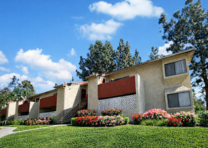 A building with a red awning and a white fence.