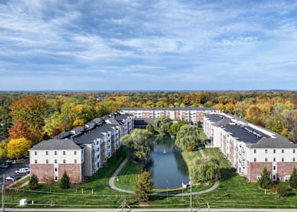A large building complex with a lake in front.