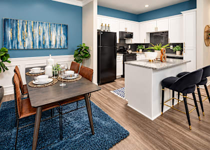 A modern kitchen with a dining table set for two.