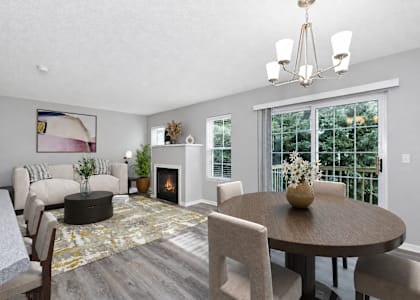 Virtually staged living and dining room at Summit Townhomes in Burnsville, MN, with a fireplace and sliding patio doors.