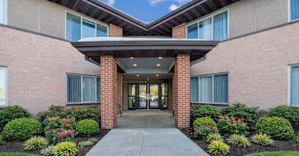 A building with a brick facade and a covered walkway leading to the entrance.