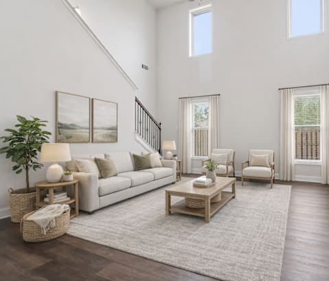 A living room with a white couch, a wooden coffee table, and a painting on the wall.