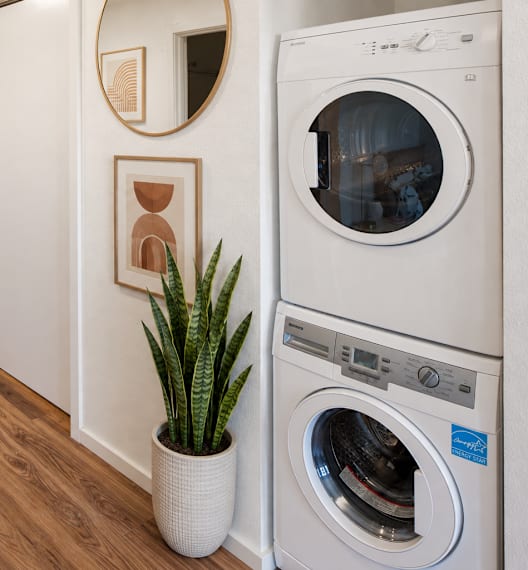 A washing machine is placed in a room with wooden flooring.