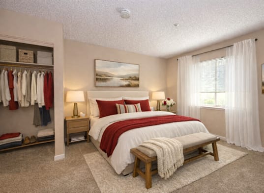 A bedroom with a large bed and a painting on the wall.