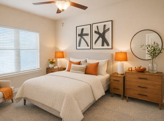 A bedroom with a large bed, a chair, and two lamps.