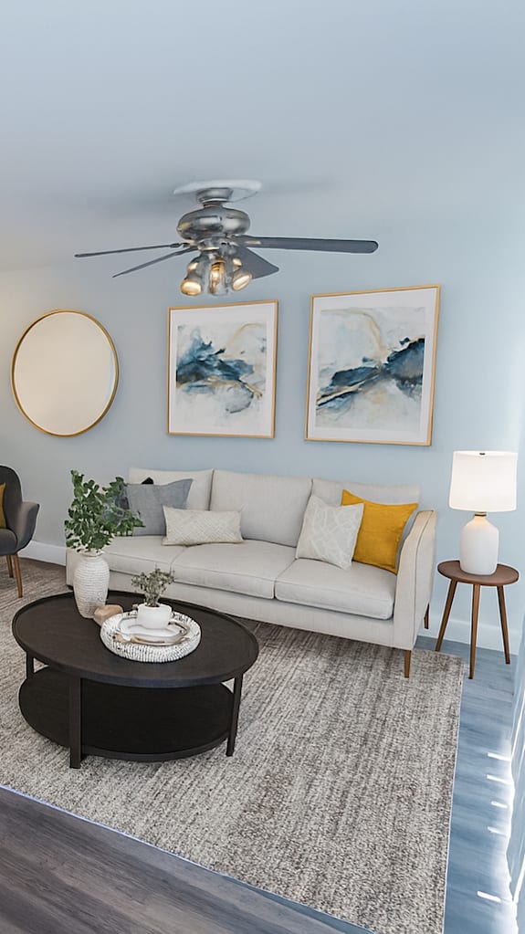 A living room with a television, a couch, and a plant.