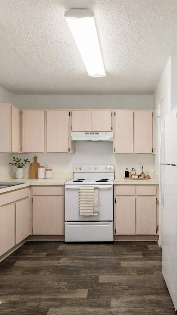 A modern kitchen with white cabinets and a black fridge.