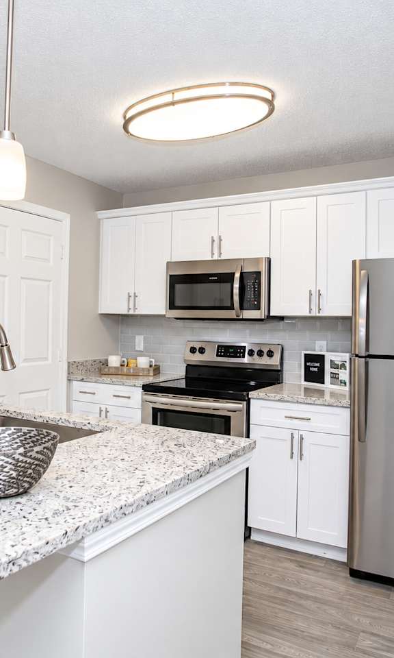 A kitchen with a granite countertop and stainless steel appliances.