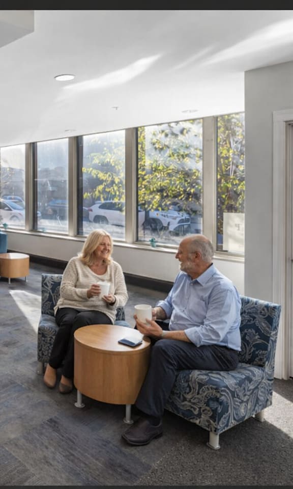 A group of people are sitting in a room with a large window.