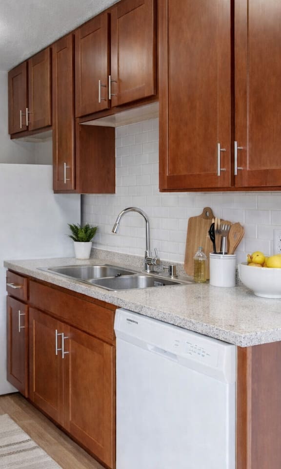 A kitchen with brown cabinets and a white fridge.