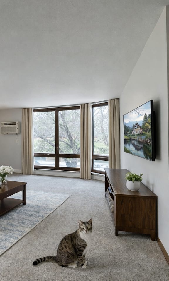 A cat is sitting on the floor in a living room.