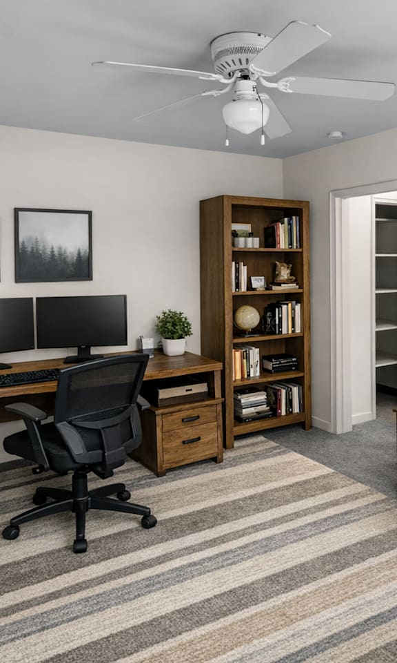 A room with a desk, chair, and bookshelf.