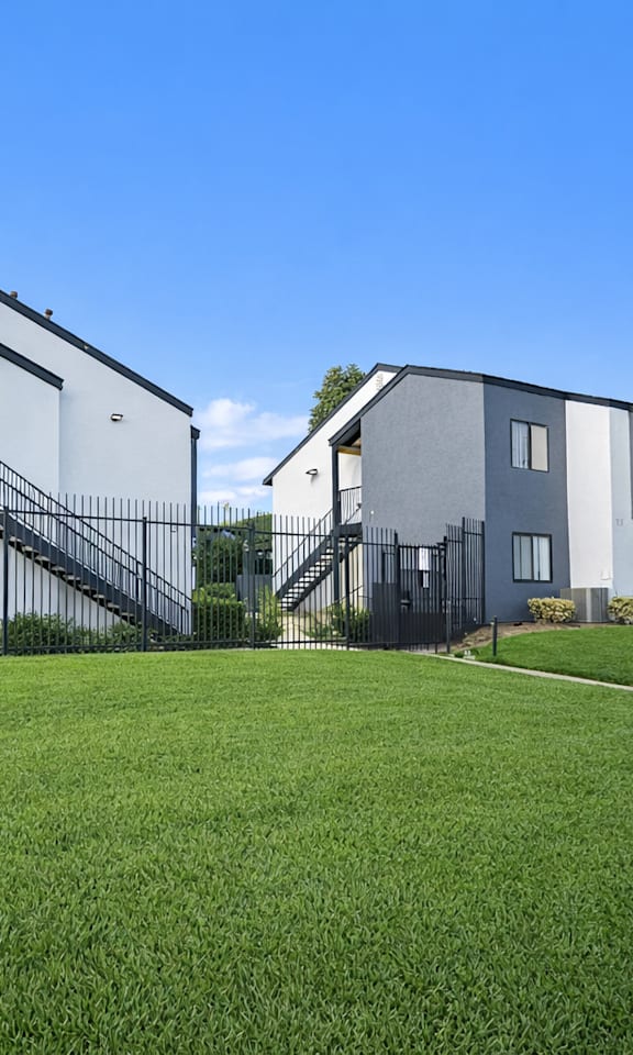 A row of modern houses with white walls and dark roofs.