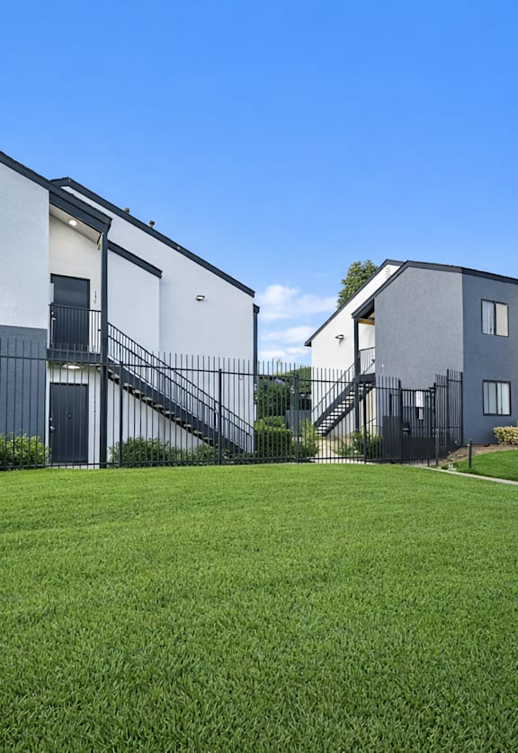 A row of modern houses with white walls and dark roofs.