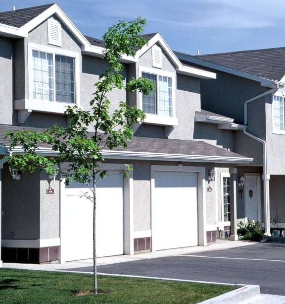 a row of houses with white garage doors