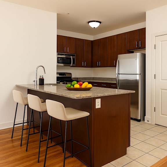 A kitchen with a bar area and a refrigerator.