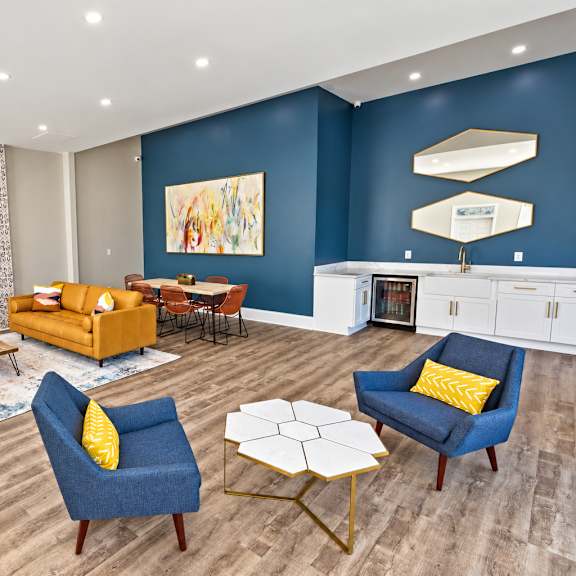 A living room with a blue accent wall and a television mounted on the wall.