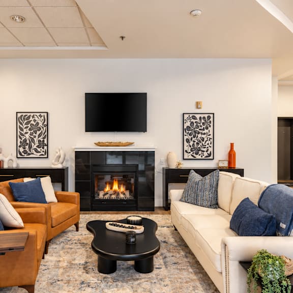 A living room with a fireplace and a television on the wall.